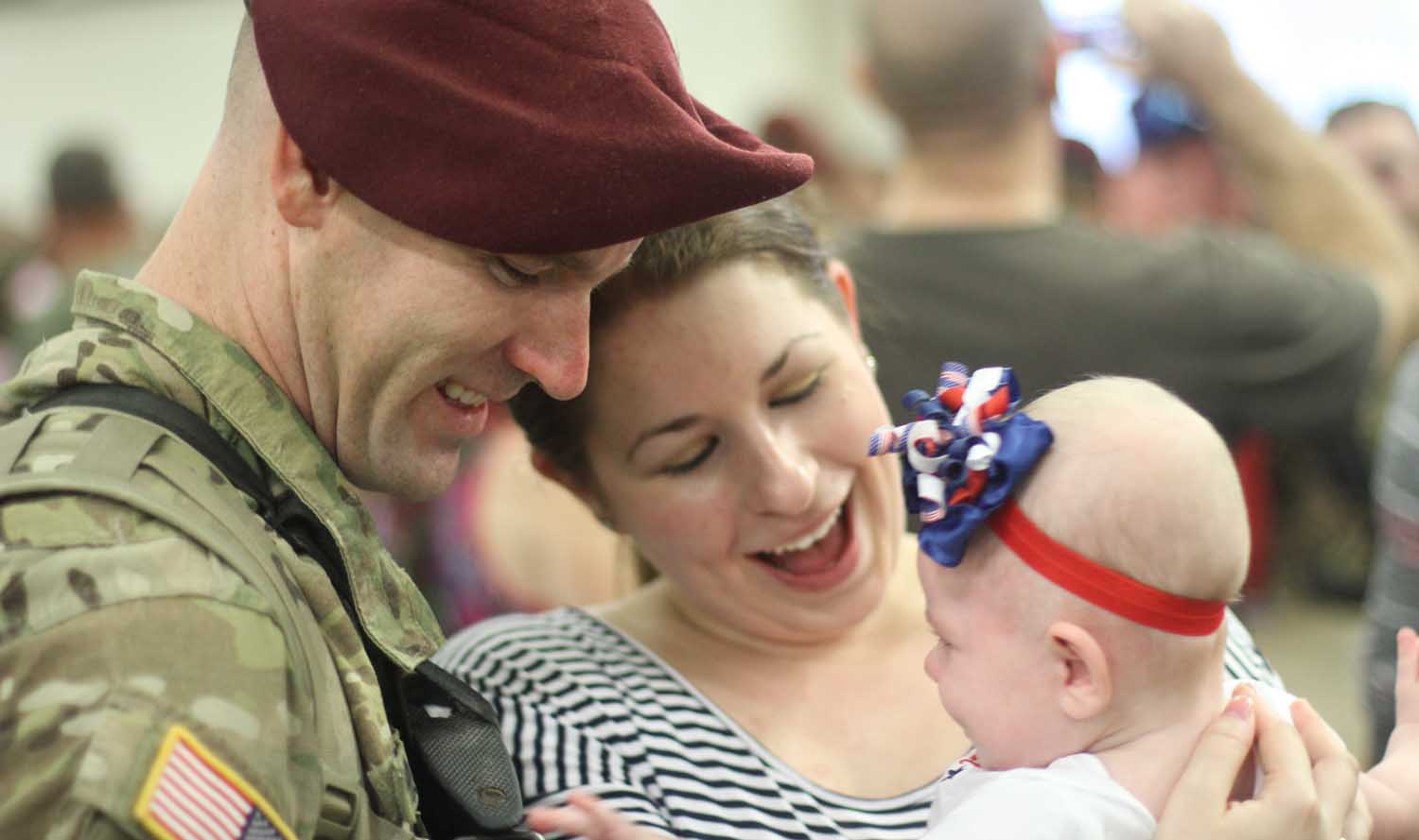 A family member of a paratrooper assigned to 3rd Brigade Combat Team, 82nd Airborne Division embraces his family members upon his redeployment at Green Ramp on Fort Bragg, N.C., Sept. 20, 2015. The paratroopers returned from a nine-month deployment to Iraq in support of Combined Joint Forces Land Component Command - Iraq during Operation Inherent Resolve. (U.S. Army photo by Sgt. Anthony Hewitt/Released)